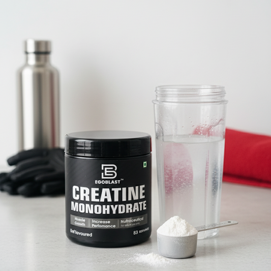 Creatine monohydrate supplement container with a shaker and scoop on a white surface.